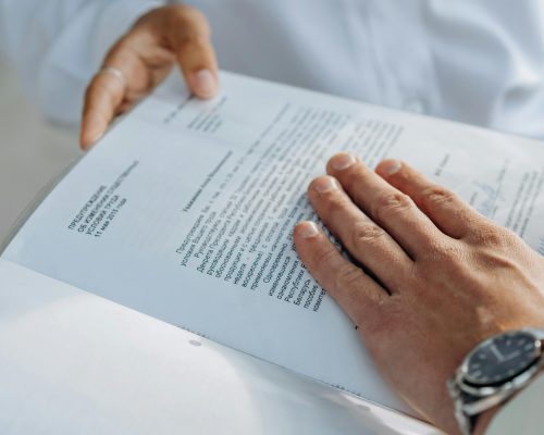 Close-up of hands reviewing a business agreement document. Professional setting.